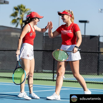Two female tennis players in red and white