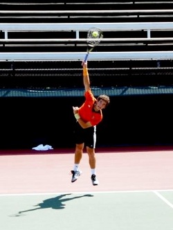Male tennis player playing a forehand smash